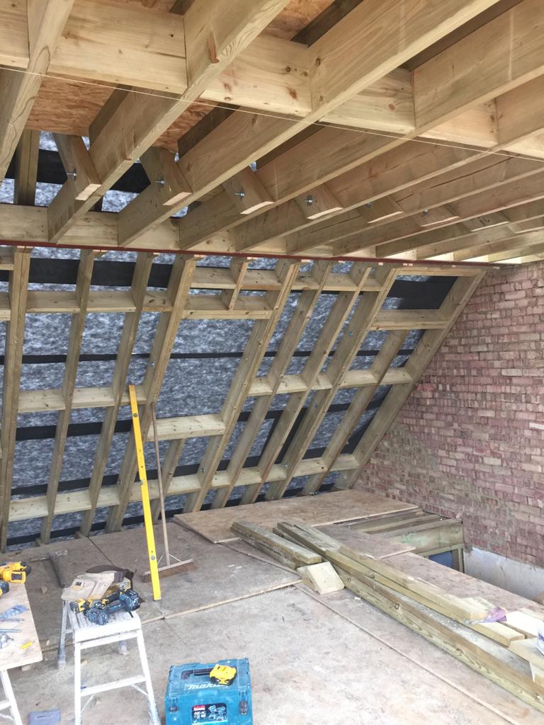 Timber roof rafters and breathable membrane inside a loft before insulation